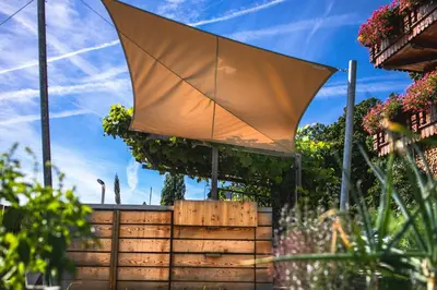 a retractable canopy in a garden with flowers at haus urban in Barbiano
