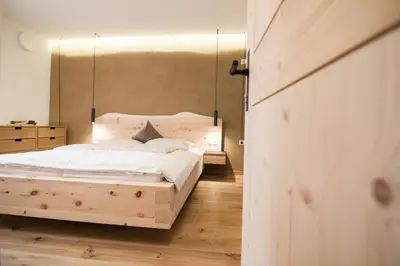a bedroom with a bed with a wooden headboard at haus urban in Barbiano