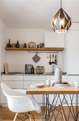 a kitchen with a wooden table and white chairs at haus urban in Barbiano