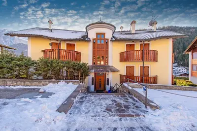a house with snow in front of it at Apartment Belvedere in Selva di Val Gardena