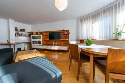a living room with a table and a tv at Apartment Belvedere in Selva di Val Gardena