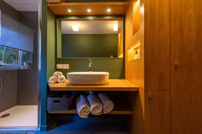 a bathroom with a sink and a mirror and towels at Apartment Belvedere in Selva di Val Gardena