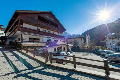 a building with a car parked in a parking lot at Apartments Sal Feur in Selva di Val Gardena