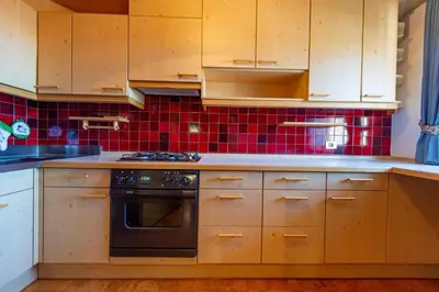 a kitchen with wooden cabinets and a stove top oven at Apartments Sal Feur in Selva di Val Gardena