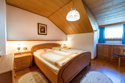 a bedroom with a bed and a wooden ceiling at Apartments Sal Feur in Selva di Val Gardena
