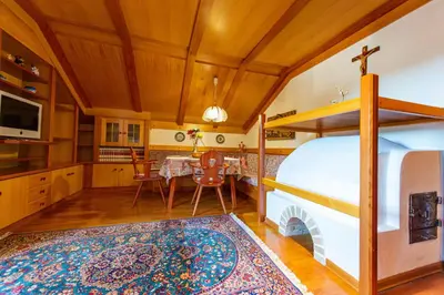 a kitchen and dining room with a bed and a fireplace at Apartments Sal Feur in Selva di Val Gardena