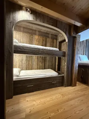 a room with two bunk beds in a wooden wall at Studio Ebi Vacation - Alleghe - Monte Civetta in Alleghe