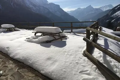 a picnic table covered in snow next to a fence at Studio Ebi Vacation - Alleghe - Monte Civetta in Alleghe