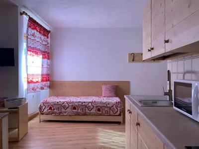 a kitchen with a bed in a small room at Casa Mammolo Falcade in Falcade