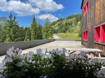 a parking lot with a bench next to a building at Casa Mammolo Falcade in Falcade