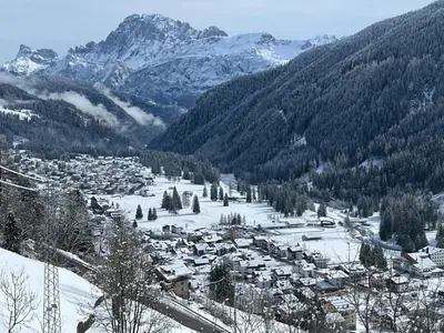 a small town in the snow with mountains at Casa Mammolo Falcade in Falcade