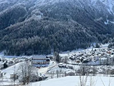 a village in the snow with a mountain at Casa Mammolo Falcade in Falcade