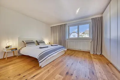a bedroom with a large bed and a large window at HOMESTWENTY3 - Home two in Caldaro