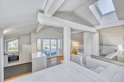 a kitchen and living room with white walls and a skylight at HOMESTWENTY3 - Home two in Caldaro