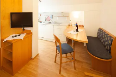 a small room with a desk and a table with a television at Residence Preyhof in Caldaro