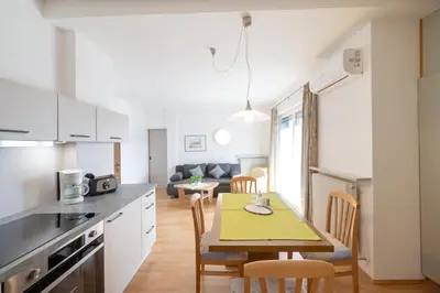 a kitchen and living room with a table and chairs at Residence Preyhof in Caldaro