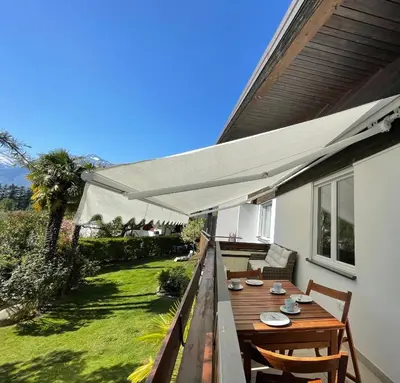 a patio with a table and chairs under awning at Naif-Home in Merano