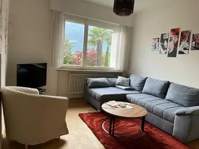 a living room with a blue couch and a table at Naif-Home in Merano