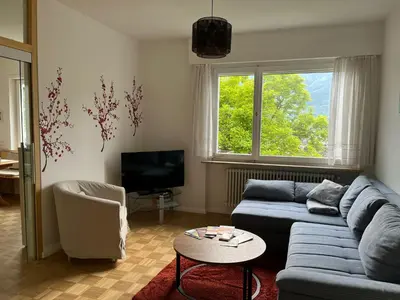 a living room with a blue couch and a tv at Naif-Home in Merano