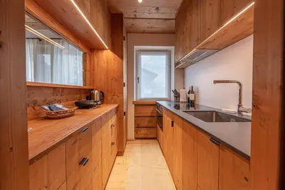 a large kitchen with wooden cabinets and a sink at Casa del Lupo in Cortina dʼAmpezzo