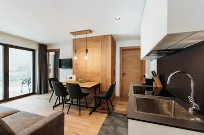a kitchen and dining room with a table and chairs at Höllerhof Brixen in Albes