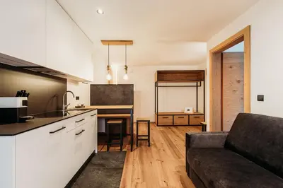 a kitchen and a living room with a couch at Höllerhof Brixen in Albes