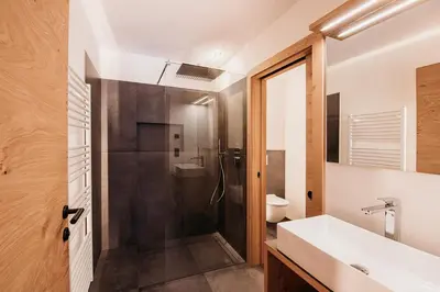 a bathroom with a shower and a sink and a toilet at Höllerhof Brixen in Albes