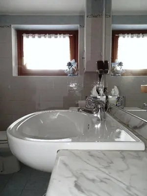 a bathroom with a white tub and a sink at Casa Minela in Falcade