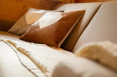 a couch with two pillows on it with at Hotel Chalet Giasenei in Sagron Mis