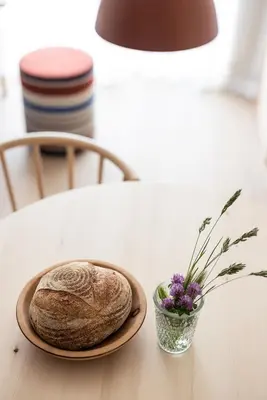 a plate of bread and a vase of flowers on a table at Mondschein Apartments in Lana