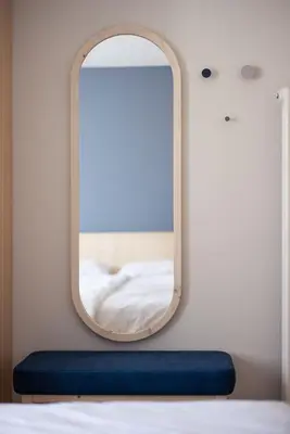 a mirror on a wall next to a bed at Mondschein Apartments in Lana