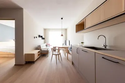 a kitchen and living room with a table and a bed at Mondschein Apartments in Lana