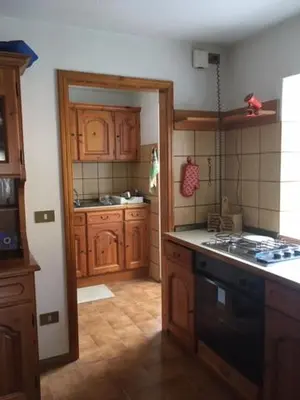 a kitchen with wooden cabinets and a stove top oven at Piccola Stella Alpina in Canale dʼAgordo