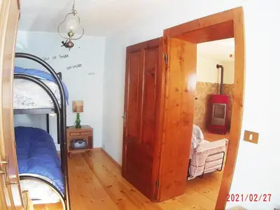 a bedroom with a bunk bed and a wooden door at Piccola Stella Alpina in Canale dʼAgordo