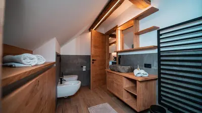 a bathroom with a white toilet and a sink at Apartments, Guest House & historic Chalet Neuhaus in San Sigismondo