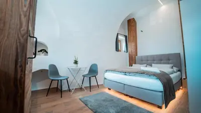 a bedroom with a bed and two chairs and a table at Apartments, Guest House & historic Chalet Neuhaus in San Sigismondo