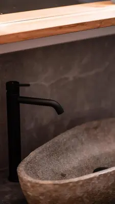 a stone sink in a bathroom with a wooden counter at Apartments, Guest House & historic Chalet Neuhaus in San Sigismondo