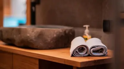 a bathroom counter with two towels and a sink at Apartments, Guest House & historic Chalet Neuhaus in San Sigismondo