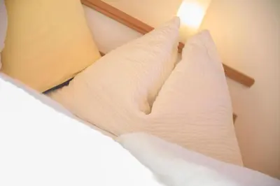 a bed with white pillows and a light on it at Puitnhof in Caldaro