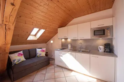 a living room with a couch and a kitchen at Puitnhof in Caldaro