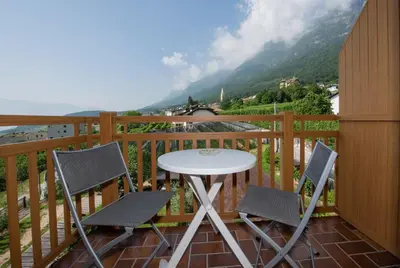 a table and two chairs on a balcony with a view at Puitnhof in Caldaro