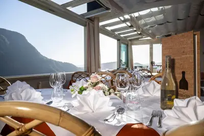 a table with wine glasses and flowers on it at Hotel Überbacher in Laion
