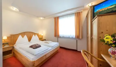 a bedroom with a bed and a large window at Hotel Überbacher in Laion