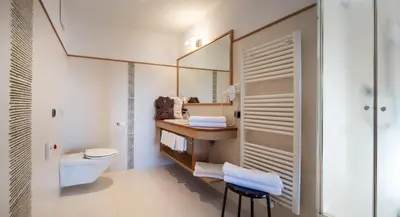 a bathroom with a toilet and a sink at Hotel Überbacher in Laion