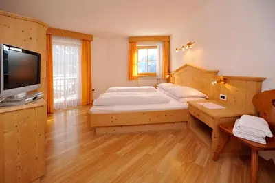 a large bedroom with a bed and a television at Hotel Überbacher in Laion