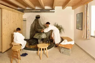 a couple of men in a room with a statue at Hotel Bad Bergfall in Valdaora