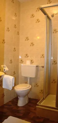 a bedroom with two beds and a cross on the wall at Hotel Bad Bergfall in Valdaora