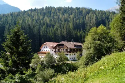 a large building with snow on top of it at Hotel Bad Bergfall in Valdaora