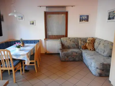 a teddy bear sitting on a couch in a living room at Residence Hofer in Valdaora