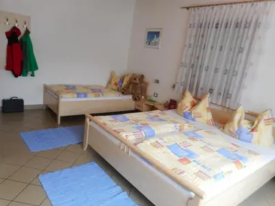 two beds in a room with blue rugs at Residence Hofer in Valdaora
